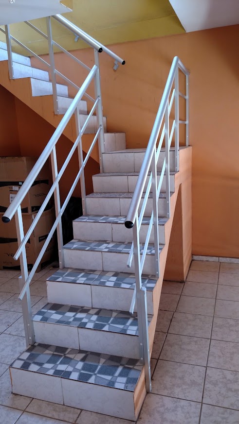 Corrimão e guarda-corpo brancos acompanhando uma escada
