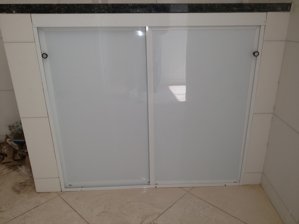 Fechamento branco com duas portas de correr sob uma bancada