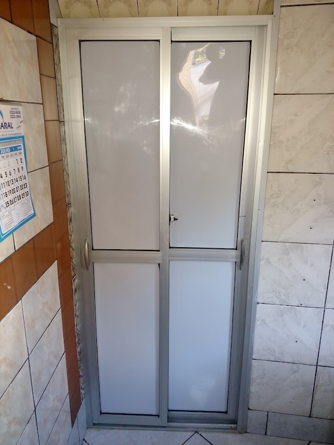Porta branca de duas folhas instalada em vão revestido